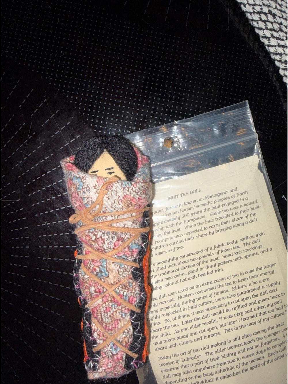 A handmade traditional Inuit tea doll with its original informational tag.